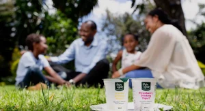 Parents playing with kids with Palmhouse Dairies yogurt. Focus on yogurt